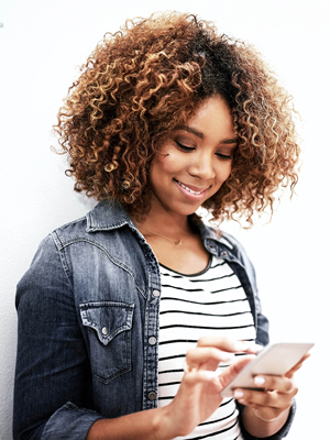 A girl looking typing on her phone. 